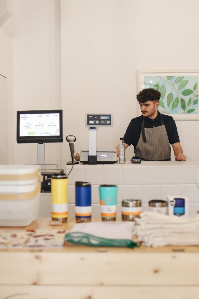 Young man managing a zero waste retail store, focused on ethical shopping and sustainability.